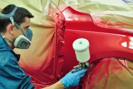 Worker painting a car.